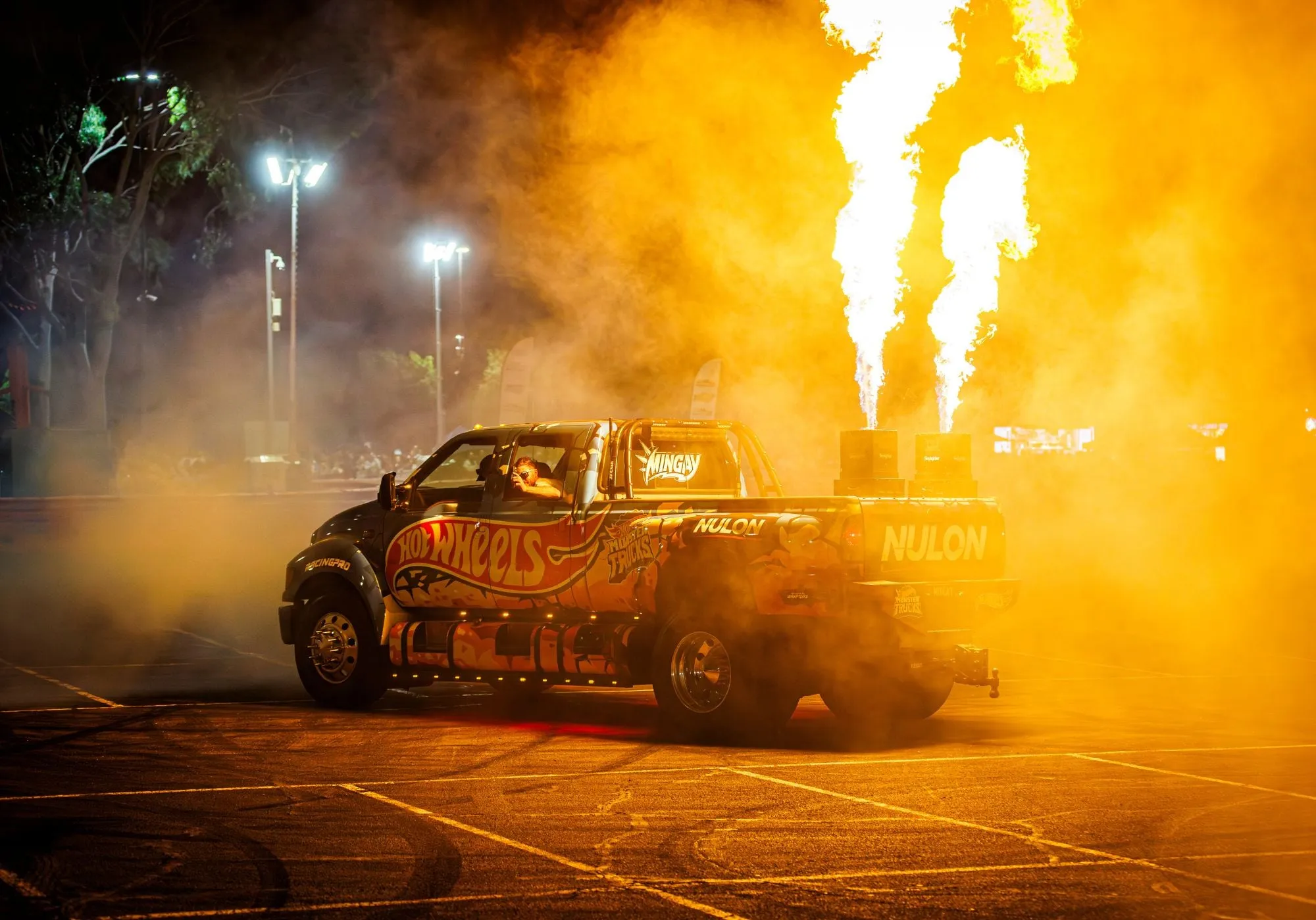 A ute spitting flames in a cloud of smoke at MotorEx