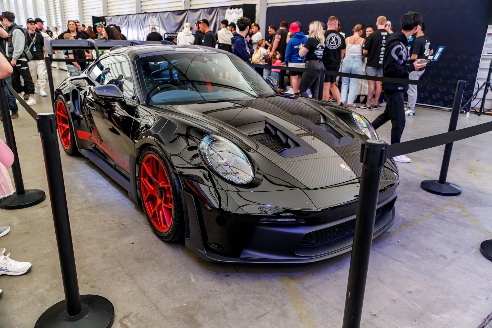 A black Porsche with red wheels in Portelli World